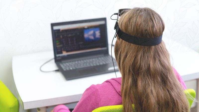 Child receiving neurofeedback brain training session with EEG headband — neurofeedback for children